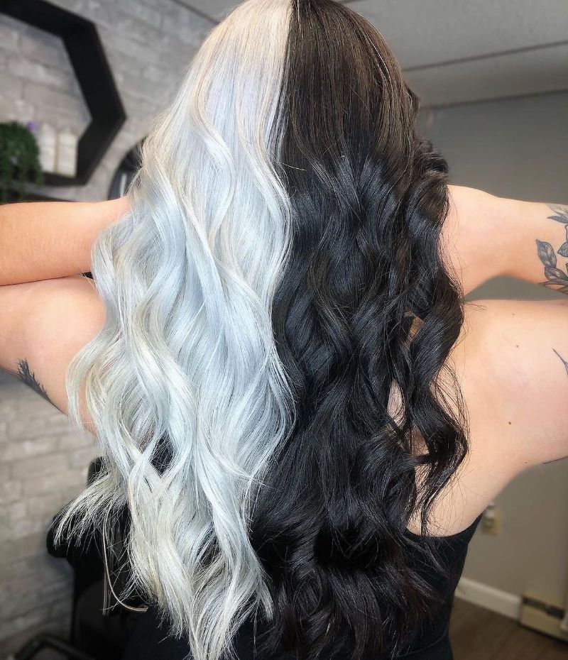 Woman with half black and half white wavy hairstyle, showcasing unique dual-toned Split Hair Dye.